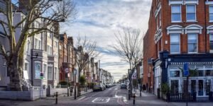 Balham High Road in South London with rows of residential houses, local shops, and pedestrians walking along the street