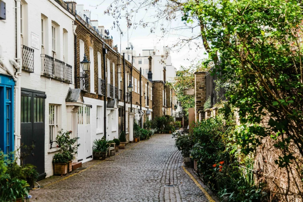 Quiet cobbled street in Bayswater London lined with period terraced houses, greenery, and residential mews-style homes near Westbourne Grove