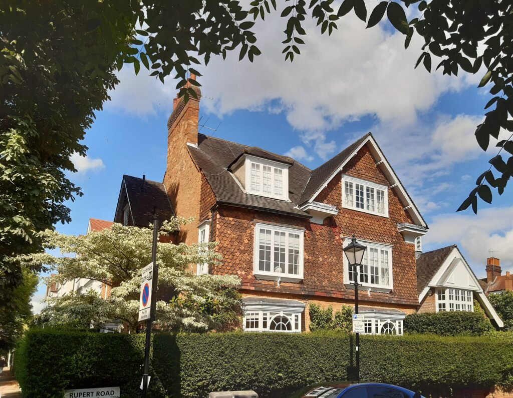 Traditional red-brick house on Rupert Road in Bedford Park London with period architecture, tree-lined street and residential garden surroundings