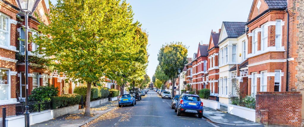 Tree-lined residential street on Devonshire Road in Chiswick London with period terraced houses and parked cars in a quiet West London neighbourhood
